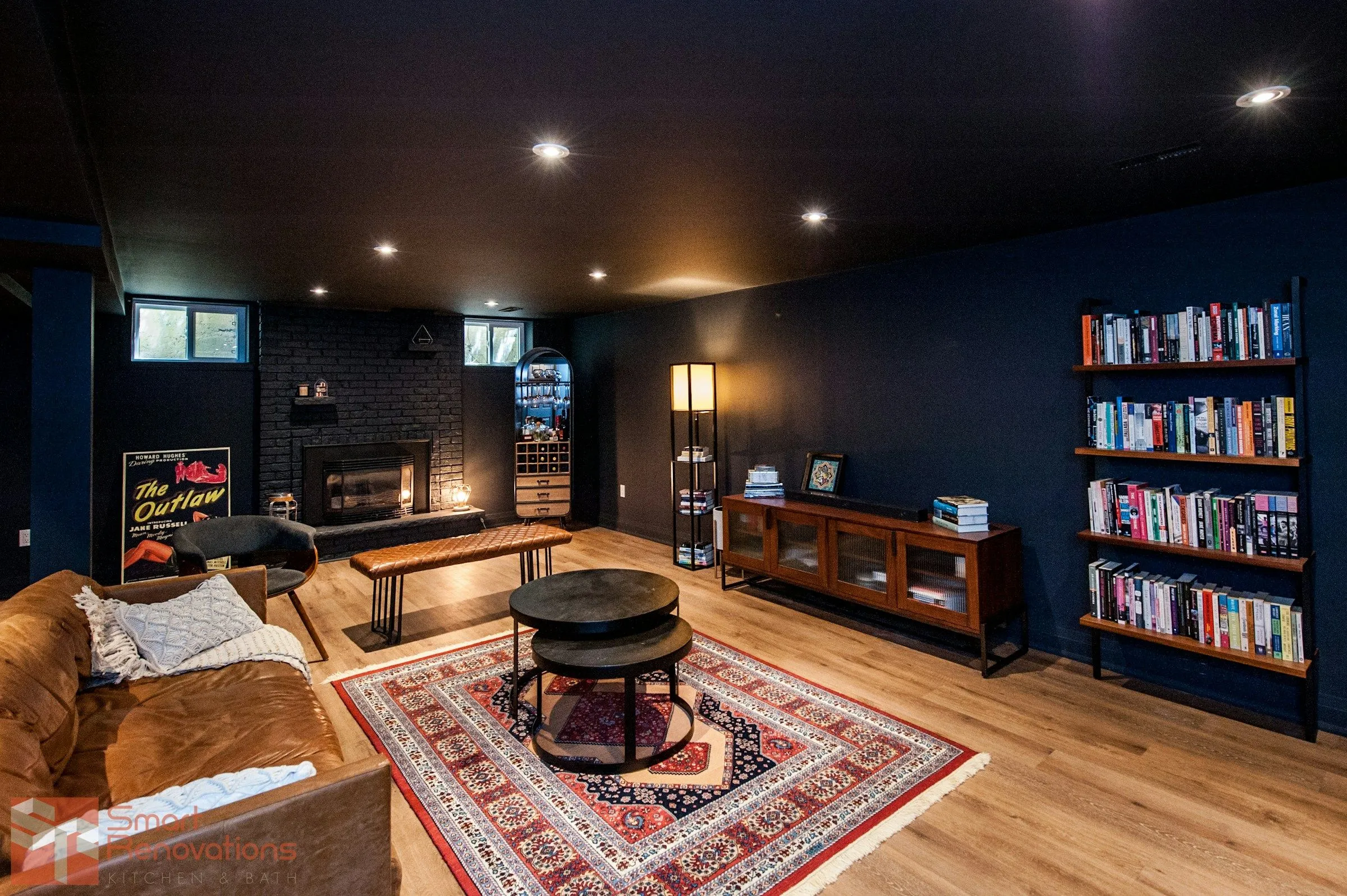 Lounge in het souterrain met leren banken, kleed en boekenwand
