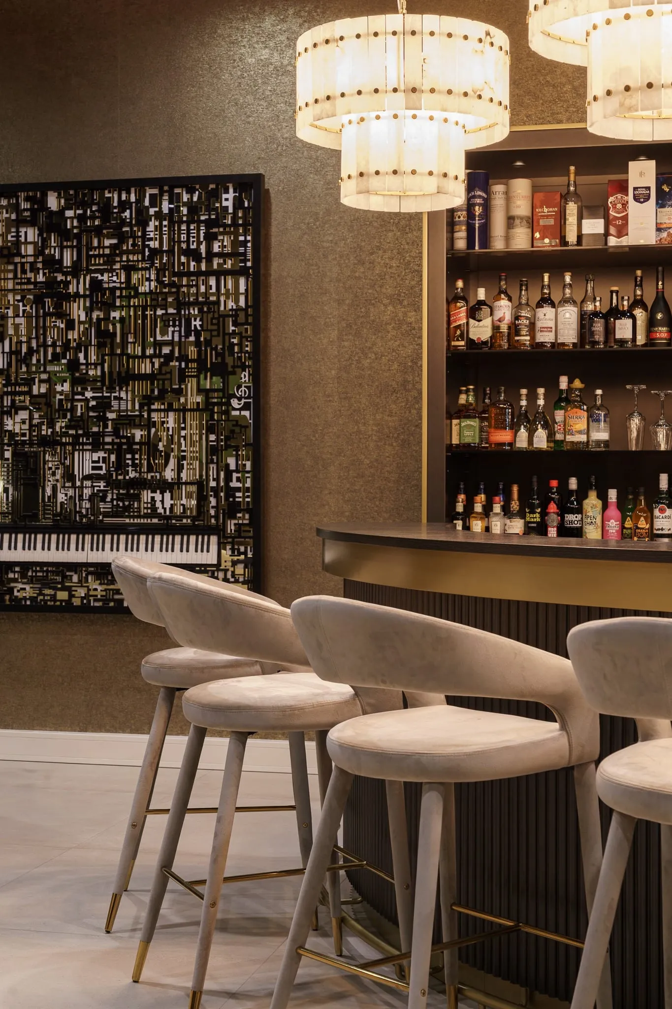 Huisbar met fluwelen krukken en een verlichte drankenwand
